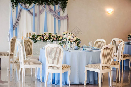 优雅的宴席桌椅配鲜花在餐厅图片