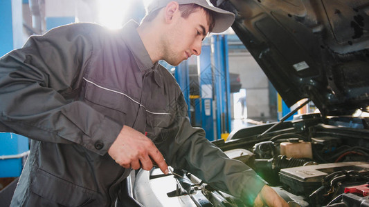 工作服机械师检查汽车中发动机油的水平汽图片