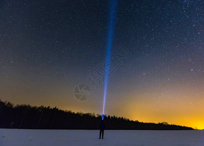 人头手电筒在星空上指着亮图片