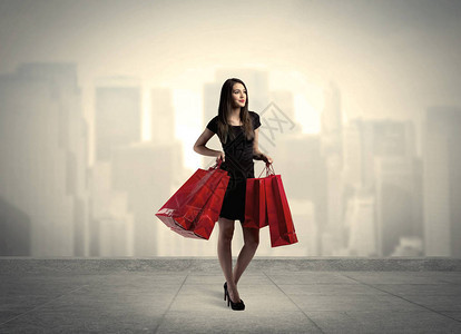 一名时髦的女站在平台和城市风景背面概念上的红色图片