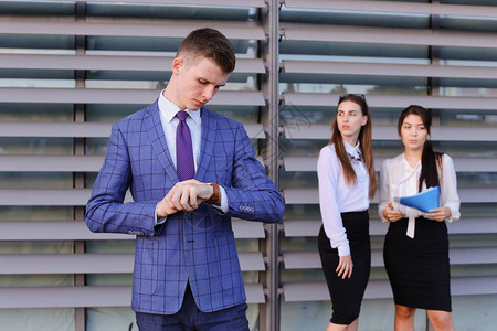 英俊自信的年轻男商人办公室工作人员学生在前置摄像头前摆姿势看手表