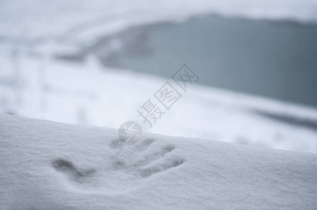 新雪中完美的手印湖山背景模糊图片