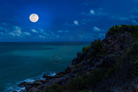 夜晚海边陡峭的悬崖和满月背景图片