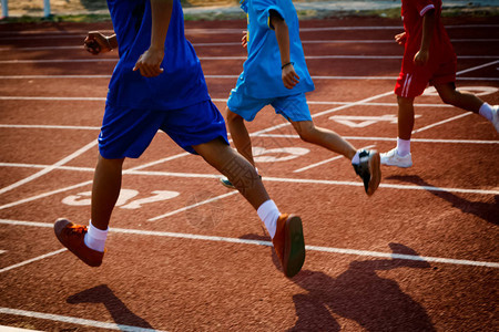 一群男孩在体育场的跑道上奔跑图片
