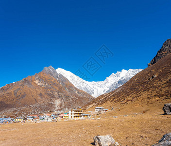 白雪皑的LangtangLirung喜马拉雅山脉的壮丽景色与尼泊尔前景的KyanjinGompa村2015年廓尔喀地震破图片