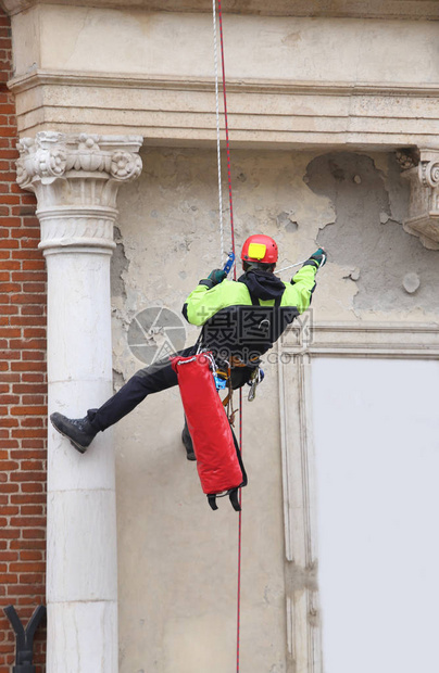 消防员在一座旧大楼上用绳索和攀爬设备监测地震后的稳定情况图片