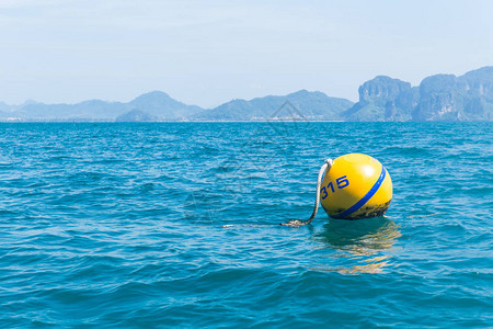 黄色浮标安全球漂浮在海洋深海区域图片