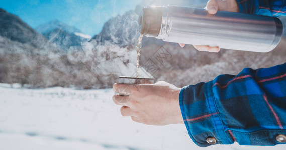 在雪山上拿着保温瓶的男人图片