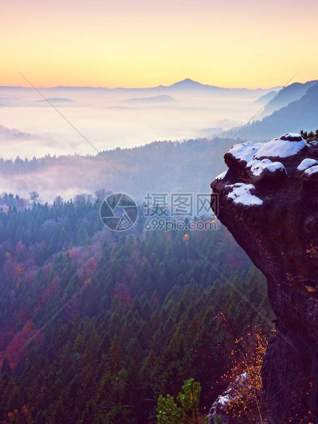 丘陵景观中的粉红色黎明初冬雾蒙的早晨在美丽的岩石山丘上大雾中的山峰图片