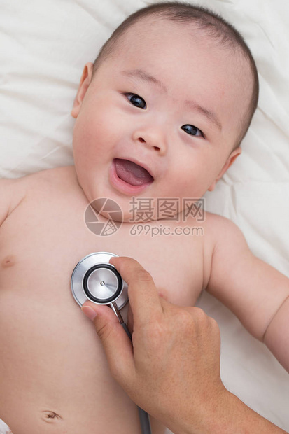 医生用听诊器听婴儿的胸部图片