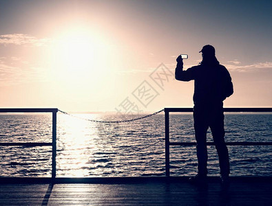 海鼹鼠的旅游照片远足者拍早晨海的照片码头木板上的游客图片