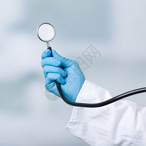 手持套的医生拿着听诊器背景图片