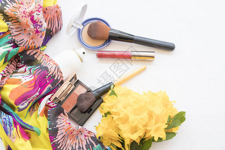 女在收集夏季黄色花朵时化妆品中的美容图片