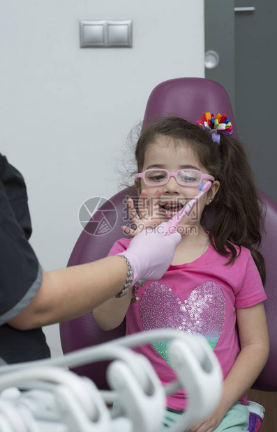 在对小女孩进行牙科干预期间与一名病人一图片