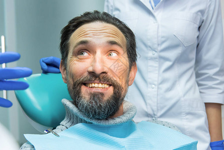 在牙医面前微笑的男人成年男笑脸背景图片