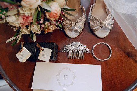 桌子上摆着婚礼饰品鲜花和伴娘鞋背景