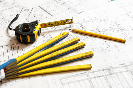 带尺子的卷尺黄色铅笔和可折叠尺子在建筑蓝图计划上的图像建图片