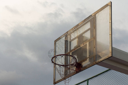 暴风雨天空背景下的篮球板和篮筐上的一点阳光图片