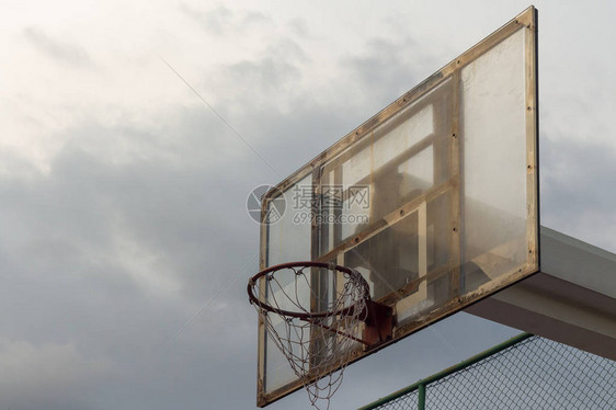 暴风雨天空背景下的篮球板和篮筐上的一点阳光图片
