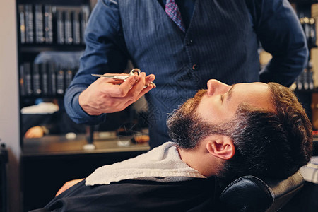 理发师的特写肖像剪掉了男人的胡须图片