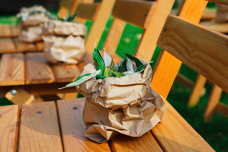 户外婚礼装饰细节特写用绿色植物布置装饰的木椅供客人使用的座图片