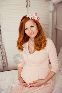 穿着粉红色连衣裙的红头发孕妇图片