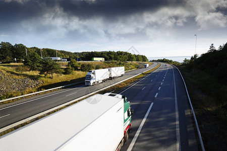 公路运输乘卡车在观光高速公路上行驶高视地背景