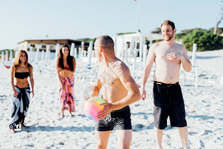 夏令营banner一群千百年的朋友在海滩上玩沙滩球活动背景