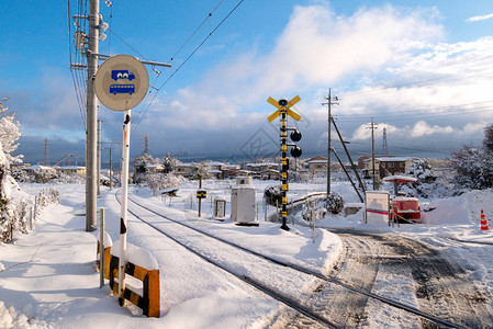 与白色的雪落在寒冬季节日本当地火车的铁路轨道图片