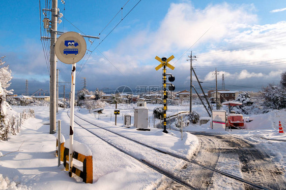 与白色的雪落在寒冬季节日本当地火车的铁路轨道图片