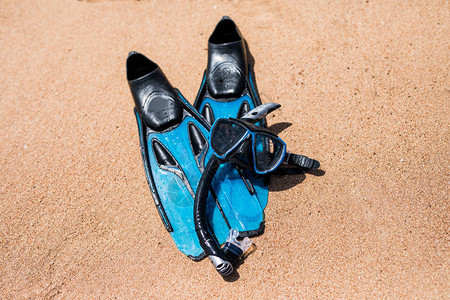海滩度假乐趣浮潜设备在沙滩上与海浪溅水肺潜水和浮潜黑色脚蹼图片