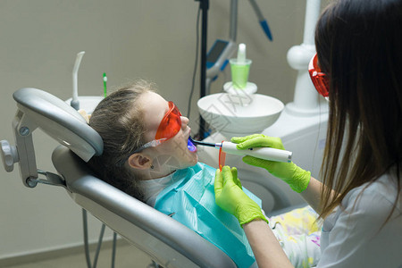 医生正在用紫外线灯做牙科补牙图片