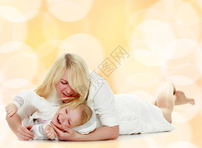 幸福的家庭母亲和小女儿躺在地板上背景图片