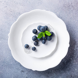 灰石背景的白板上新鲜采摘的蓝莓健康饮食和营养的概念与复制空间图片
