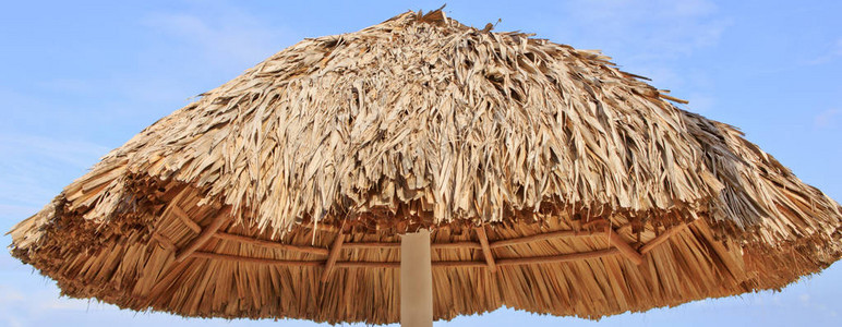 加勒比蓝天空和沙滩遮阳带稻草屏图片
