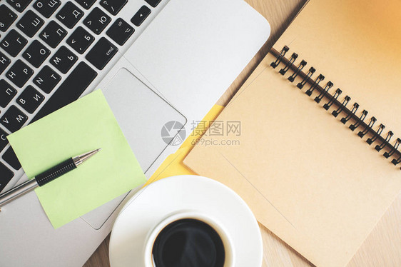 带有键盘咖啡杯和螺旋笔记板的木制办公图片