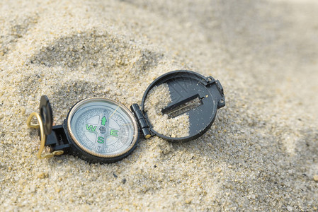 指南针躺在海热的沙滩上水平视图背景图片