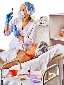 男前额面部填充剂注射美容诊所的整形美容面部手术背景是折叠的毛巾用注射器注射鼻唇沟的医用手图片