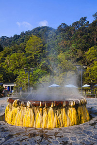 具有蒸汽泉和太阳的火山天然温泉矿物水池图片