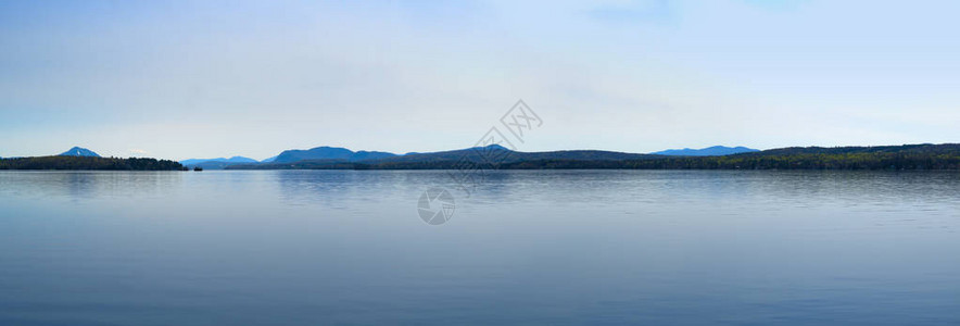 平静的湖泊蓝水和蓝天空反射山脉图片