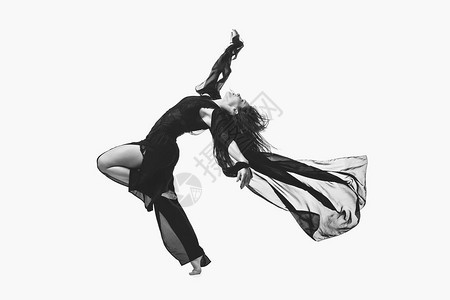 美丽的现代舞者年轻女子在黑色飞行面料制作舞蹈动作在白色背景上隔离复图片