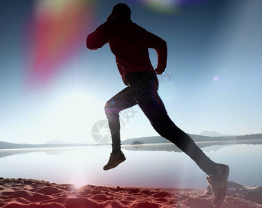 活跃的运动员赛跑者在日出岸上奔跑的剪影早晨在沙滩上进行健康生活方式锻炼男图片