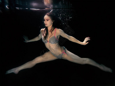 在黑暗背景的瑜伽中做下水肖像年轻有吸引力的美女图片