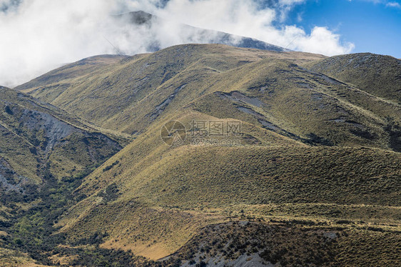 高山脉与顶部在中土岩石在蓝天白云下高沙漠山地风光页岩卵图片