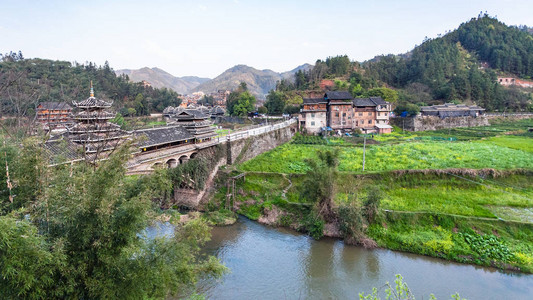 春季在三江东自治县成阳村河流附近大桥和花园的景象图片
