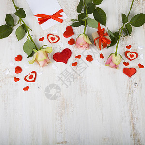 粉红玫瑰礼物和心放在木制背景上情人节生日图片