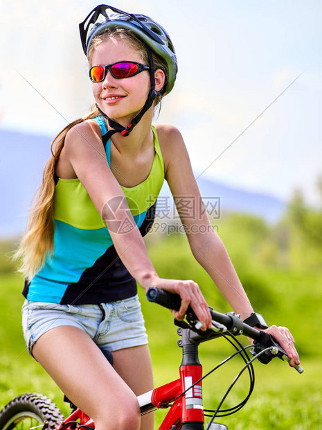 夏天公园里的女人旅行自车用于在绿草反对蓝天白云上运行的女子公路自行车骑自行车旅行有益于健康学校图片