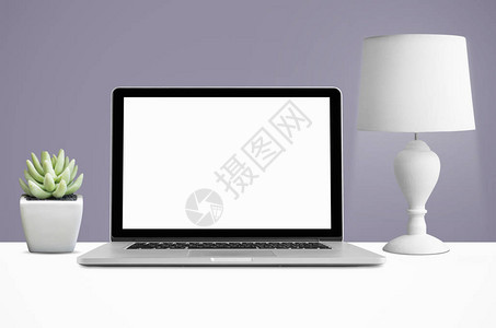 台面上有空白屏幕和灯具的膝上型手提电脑图片