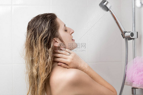 微笑的妇女洗涤在淋浴图片