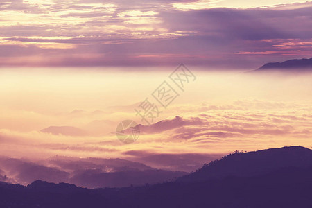 日落时云中的山脉剪影图片